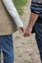 Senior couple holding hands together and walking in spring garden road. Elderly marriage in love. Relationship concept. Royalty Free Stock Photo