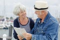 senior couple holding map by harbour Royalty Free Stock Photo