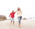 Senior Couple On Holiday Running Along Beach Royalty Free Stock Photo