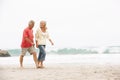 Senior Couple On Holiday Running Along Beach Royalty Free Stock Photo