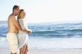 Senior Couple On Holiday Running Along Sandy Beach Looking Out To Sea Royalty Free Stock Photo