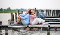 Senior couple on a holiday sitting back to back by the lake. Royalty Free Stock Photo
