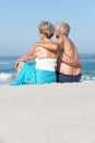 Senior Couple On Holiday Sitting On Sandy Beach Royalty Free Stock Photo