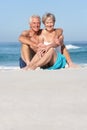 Senior Couple On Holiday Sitting On Sandy Beach Royalty Free Stock Photo