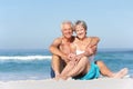 Senior Couple On Holiday Sitting On Sandy Beach Royalty Free Stock Photo