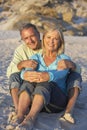 Senior Couple On Holiday Sitting On Sandy Beach Royalty Free Stock Photo