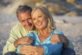 Senior Couple On Holiday Sitting On Sandy Beach Royalty Free Stock Photo