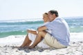 Senior Couple On Holiday Sitting On Sandy Beach Royalty Free Stock Photo