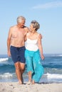 Senior Couple On Holiday Walking Along Sandy Beach Royalty Free Stock Photo