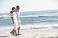 Senior Couple On Holiday Walking Along Sandy Beach Royalty Free Stock Photo
