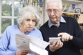 Senior Couple At Home With Bills Worried About Home Finances Royalty Free Stock Photo