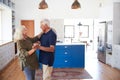 Senior Couple At Home Dancing In Kitchen Together Royalty Free Stock Photo