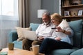 Senior couple at home. Handsome older man and attractive older woman are spending time together. Sitting on a sofa with laptop Royalty Free Stock Photo