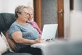 Senior couple at home having relax using laptop together. New modern lifestyle for mature retired people. Man and woman with Royalty Free Stock Photo