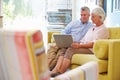 Senior Couple At Home In Lounge Using Laptop Computer Royalty Free Stock Photo