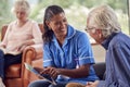 Senior Couple At Home With Man Talking To Female Nurse Or Care Worker Using Digital Tablet Royalty Free Stock Photo