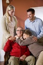 Senior couple at home on sofa with adult children