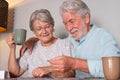 Senior couple at home spend time together doing a jigsaw puzzle on the wooden table Royalty Free Stock Photo