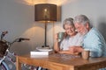 Senior couple at home spend time together doing a jigsaw puzzle on the wooden table Royalty Free Stock Photo