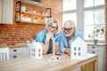 Senior couple with house models and toy wind turbine at home