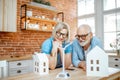 Senior couple with house models and toy wind turbine at home