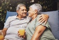 Senior couple, hug and juice on a garden patio sofa with love and care for marriage and retirement. Conversation Royalty Free Stock Photo