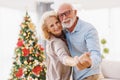 Senior couple hugging and dancing while celebrating Christmas at home Royalty Free Stock Photo