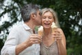 senior couple hugging and laughing together eating ice cream Royalty Free Stock Photo