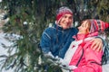 Senior couple hugging and laughing in winter forest. Man and woman walking outdoors under falling snow Royalty Free Stock Photo