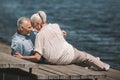 Senior couple hugging at wooden walkway at riverside