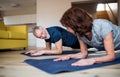 A senior couple indoors at home, doing exercise on the floor. Royalty Free Stock Photo