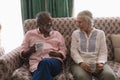 Senior couple interacting with each other while having coffee in living room Royalty Free Stock Photo