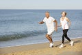 Senior Couple Jogging Along Beach Royalty Free Stock Photo