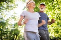 Senior couple jogging and running outdoors in nature