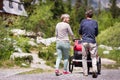 Senior couple with a jogging stroller, summer day. Royalty Free Stock Photo