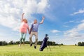 Senior couple jumping on a golf course. Royalty Free Stock Photo