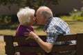Senior couple kissing each other in the park Royalty Free Stock Photo