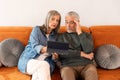 Senior Couple Learning On Digital Tablet While Sitting On Sofa Royalty Free Stock Photo