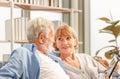 Senior couple in living room, Elderly man and a woman using tablet smartphone on cozy sofa at home, Happy family concepts Royalty Free Stock Photo