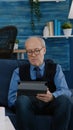 Senior man trying on tablet while his wife uses laptop Royalty Free Stock Photo