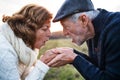 Senior couple looking at each other in an autumn nature, holding hands. Royalty Free Stock Photo