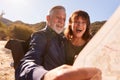 Senior Couple Looking At Map As They Hike Along Trail In Countryside Together Royalty Free Stock Photo