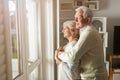 Senior couple looking out living room window