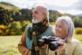 Senior couple looking at view trough binoculars on autumn walk. Royalty Free Stock Photo