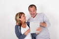 Senior couple lookint at tablet with surprised look Royalty Free Stock Photo