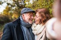 Senior couple in love in an autumn nature, taking selfie. Royalty Free Stock Photo