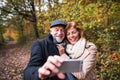 Senior couple in love in an autumn nature, taking selfie. Royalty Free Stock Photo