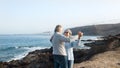 A senior couple in love dancing  on the cliff of the ocean and looking each other in the eyes. They hug each other smiling. Early Royalty Free Stock Photo