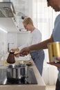 Senior couple makes fresh Turkish coffee in turk in sunny kitchen Royalty Free Stock Photo