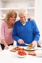 Senior Couple Making Sandwich In Kitchen